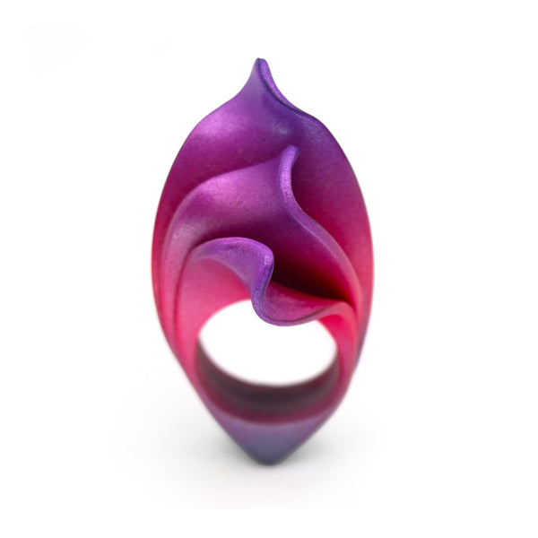 Anillo artesanal de arcilla polimérica metálica, modelado a mano uno a uno, en tonos degradados desde el violeta al magenta, con formas orgánicas que evocan el fuego.