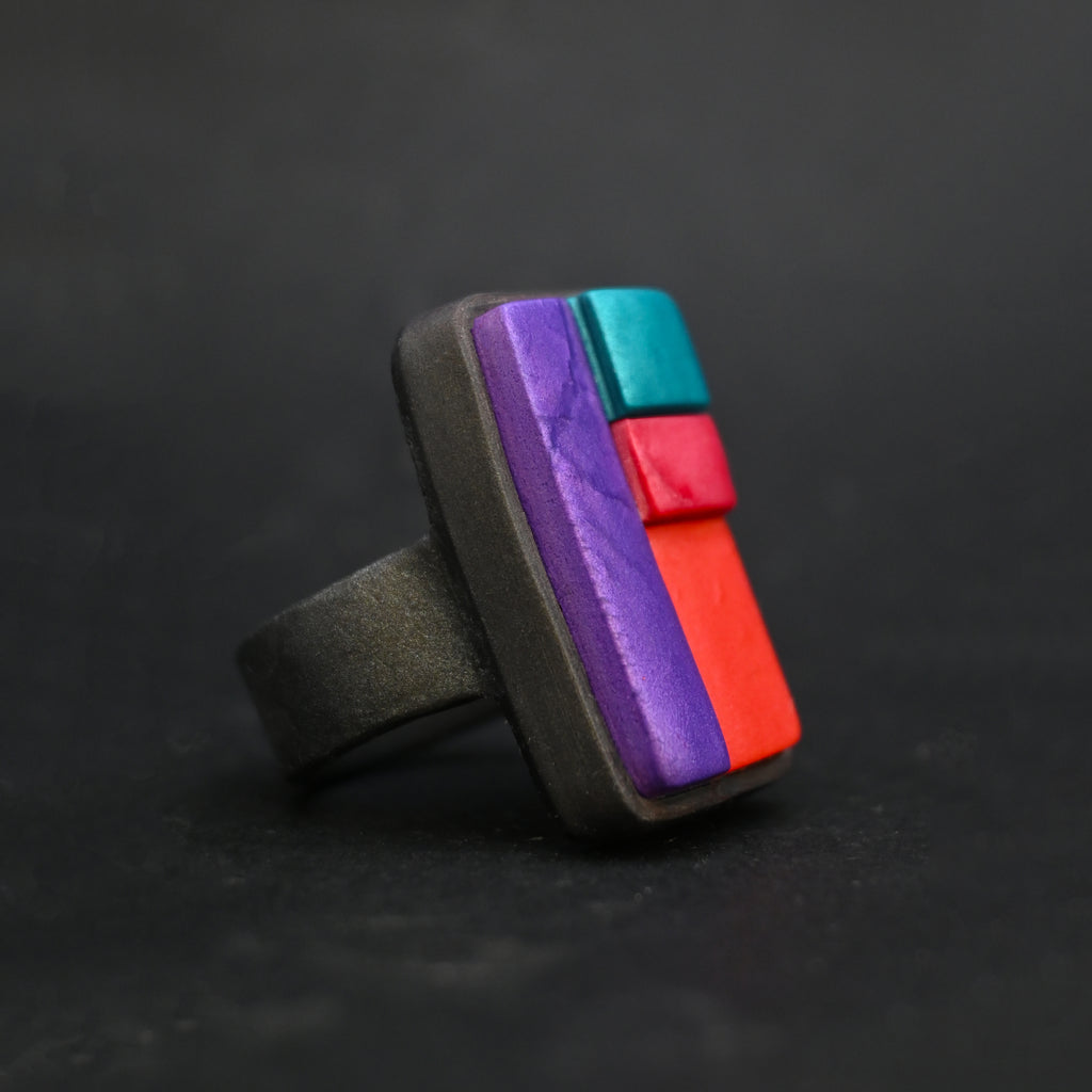 Anillo  artesanal de arcilla polimérica con diseño único formado por bloques en colores vibrantes.