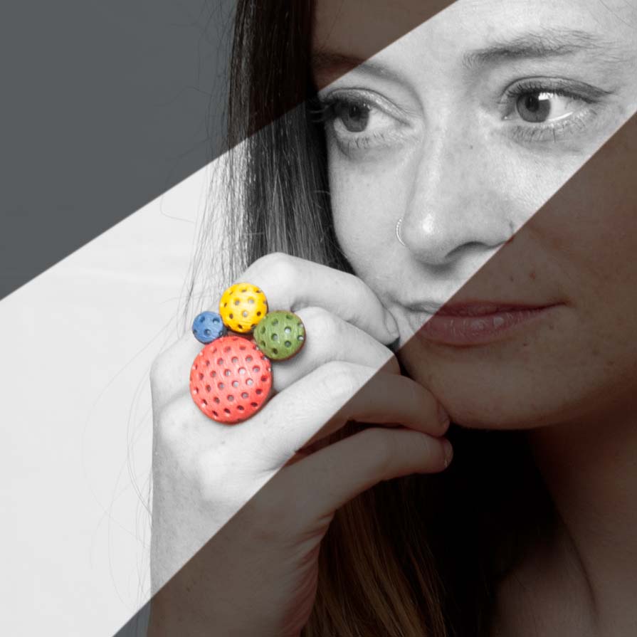 Chica luce el anillo artesanal de arcilla polimérica Polka Dots con diseño en círculos de distintos tamaños en colores vibrantes.