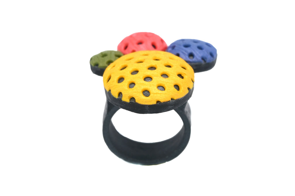 Anillo artesanal de arcilla polimérica con diseño en círculos de distintos tamaños en colores vibrantes.