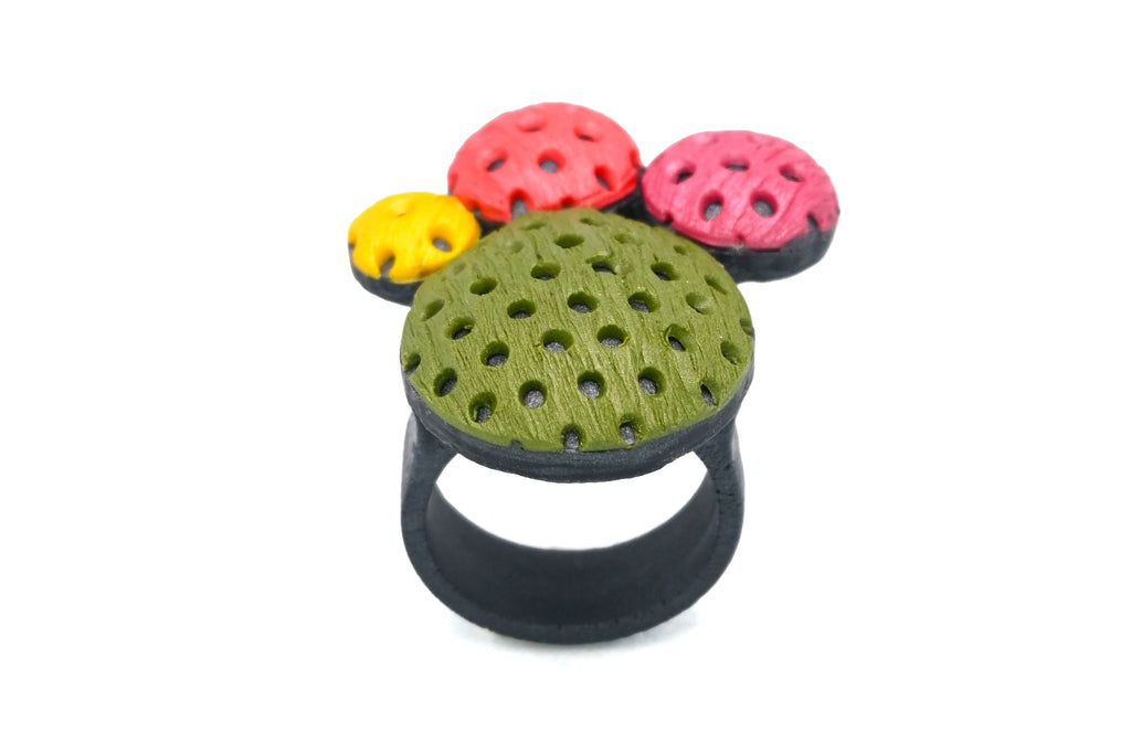 Anillo artesanal de arcilla polimérica con diseño en círculos de distintos tamaños en colores vibrantes.