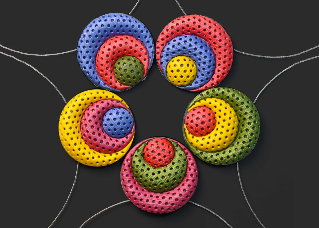 Detalle de los collares artesanales de arcilla polimérica, Polka Dots, de colores vibrantes, sobre fondo negro.