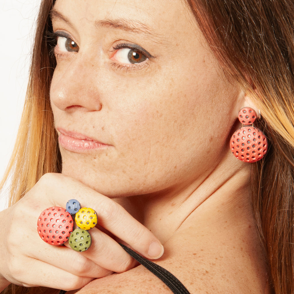 Chica luce el conjunto de anillo y pendientes artesanales de arcilla polimérica con diseño Polka Dots en colores vibrantes.
