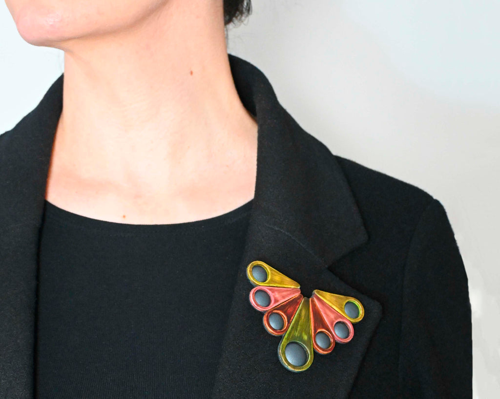 Broche artesanal Maderas-1 sobre una chaqueta negra
