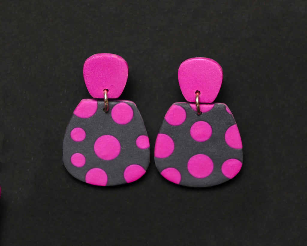 Imagen de los pendientes hechos a mano, modelo Verbena con diseño de de lunares magenta sobre fondo negro