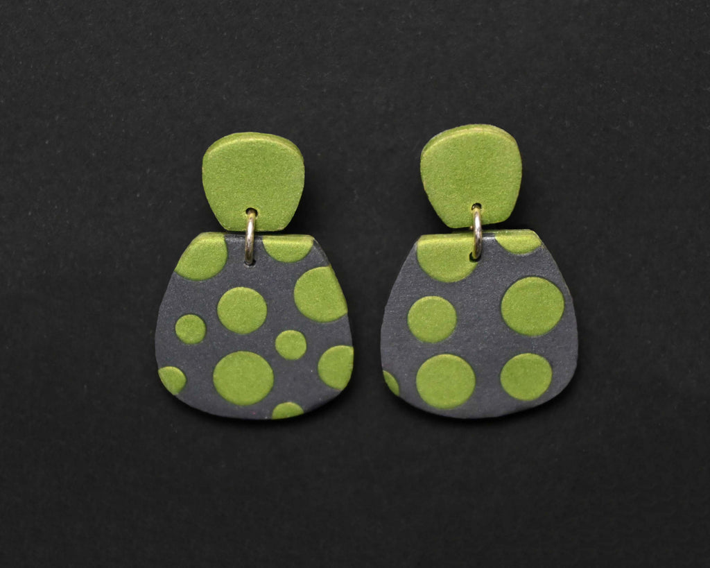 Imagen de los pendientes hechos a mano, modelo Verbena con diseño de de lunares verdes sobre fondo negro