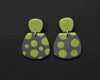 Imagen de los pendientes hechos a mano, modelo Verbena con diseño de de lunares verdes sobre fondo negro