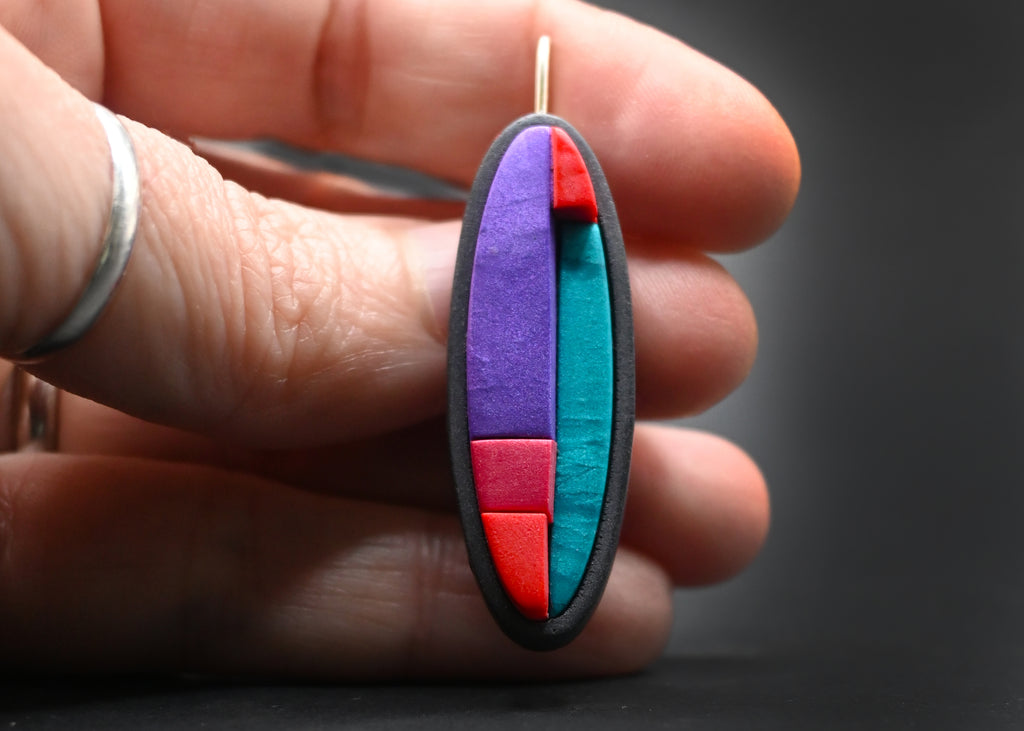 Pendientes artesanales de arcilla polimérica metálica con diseño en bloques de distintos tamaños en colores vibrantes.