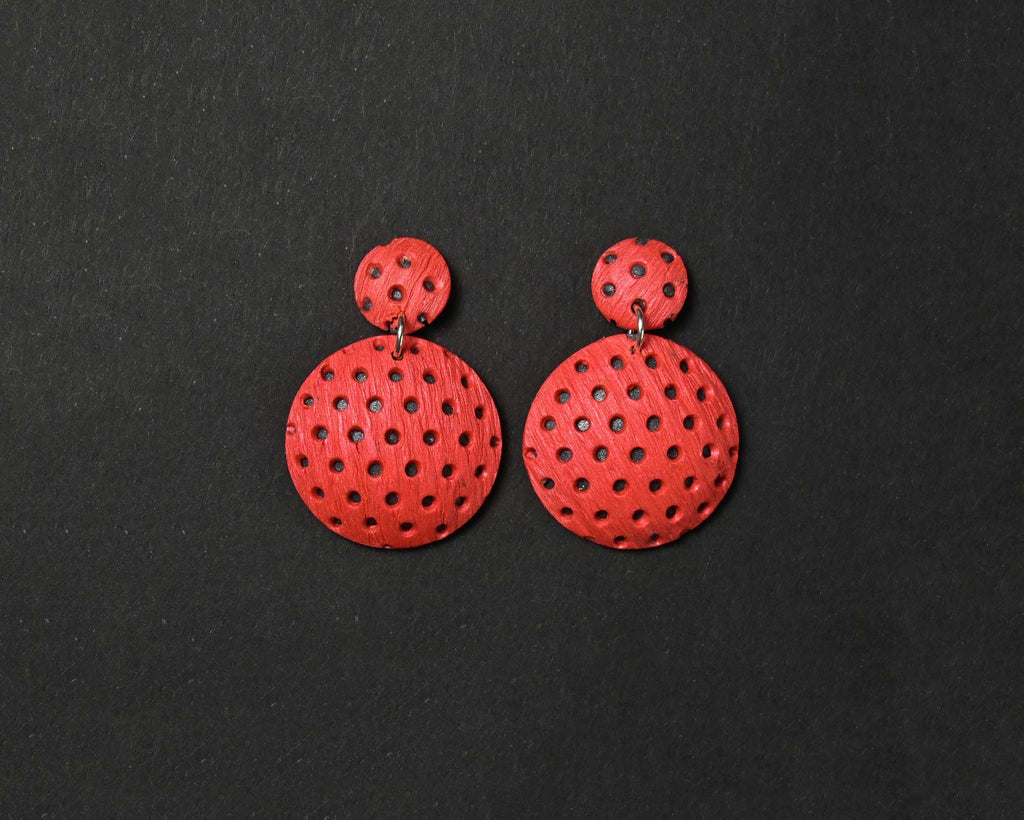 Imagen de los pendientes hechos a mano, modelo Polka Dots en color coral sobre fondo negro