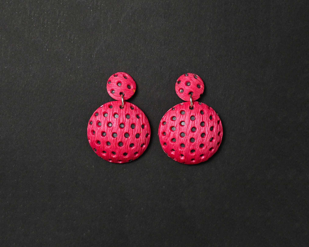 Imagen de los pendientes hechos a mano, modelo Polka Dots en color magenta sobre fondo negro