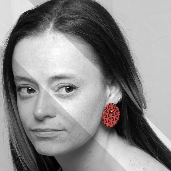 Chica los pendientes artesanales de arcilla polimérica Punk con diseño realizado con esmalte de baja temperatura en colores vibrantes.