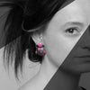 Chica luce los pendientes artesanales de arcilla polimérica Verbena con diseño en lunares en colores vibrantes.