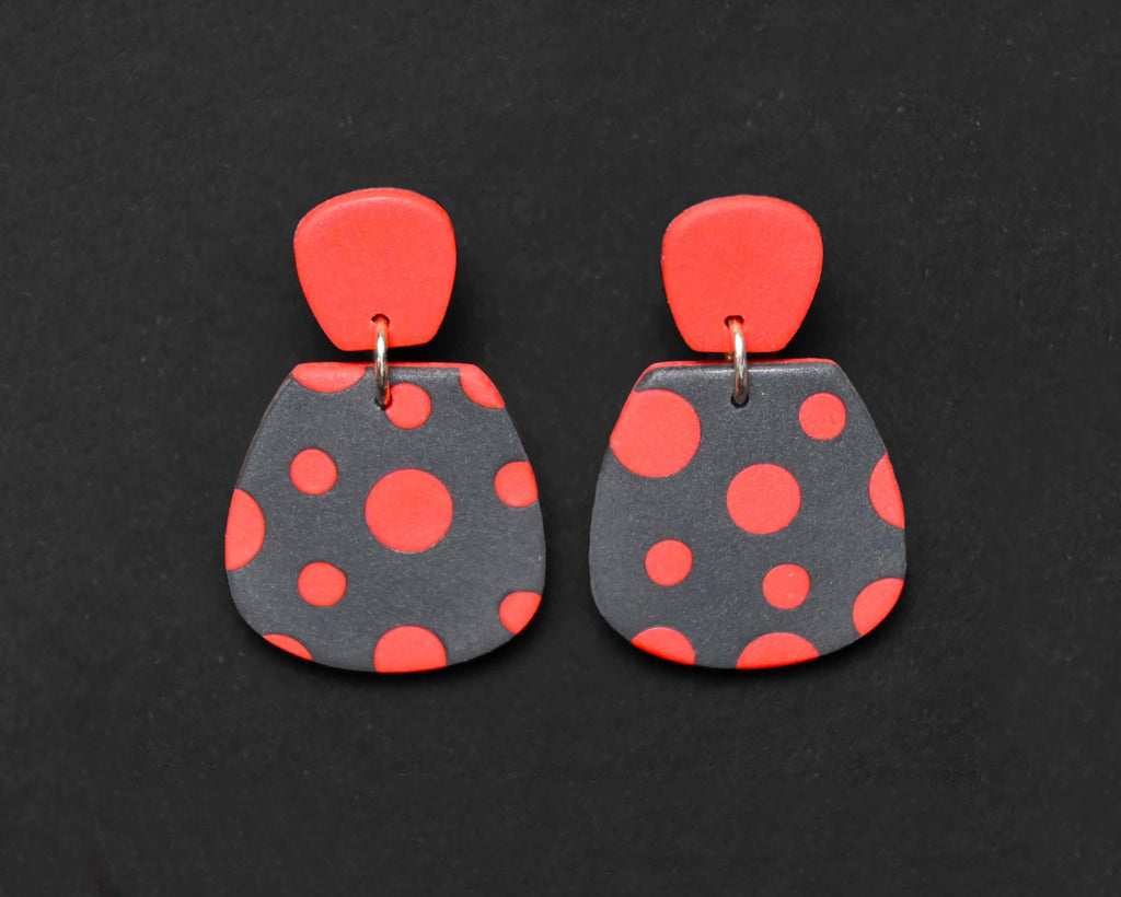 Imagen de los pendientes hechos a mano, modelo Verbena con diseño de de lunares coral sobre fondo negro