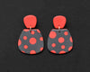 Imagen de los pendientes hechos a mano, modelo Verbena con diseño de de lunares coral sobre fondo negro