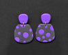 Imagen de los pendientes hechos a mano, modelo Verbena con diseño de de lunares púrpura sobre fondo negro