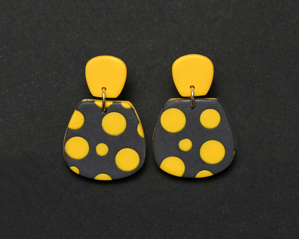 Imagen de los pendientes hechos a mano, modelo Verbena con diseño de de lunares amarillo sobre fondo negro