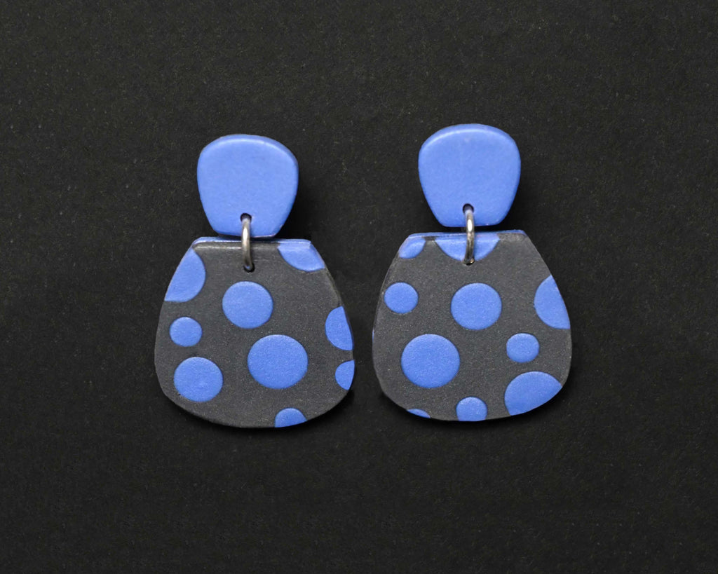 Imagen de los pendientes hechos a mano, modelo Verbena con diseño de de lunares azules sobre fondo negro