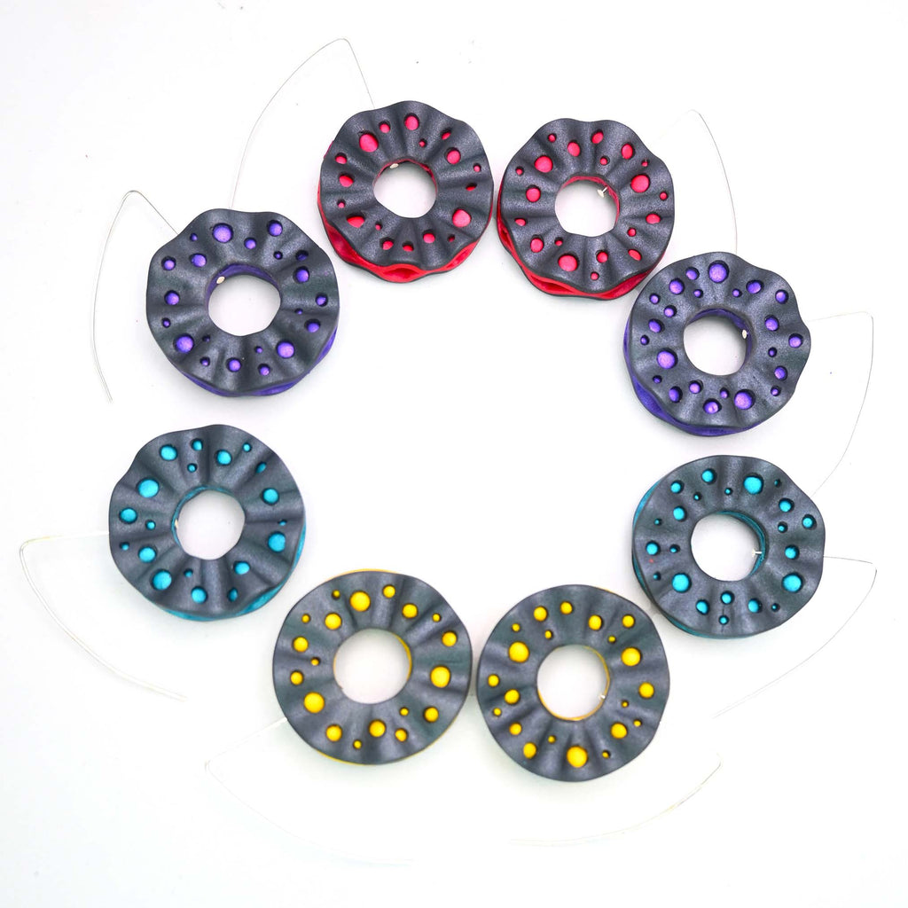 Imagen de los pendientes hechos a mano, modelo Volantes dobles en cuatro colores sobre fondo blanco, colocados en forma circular