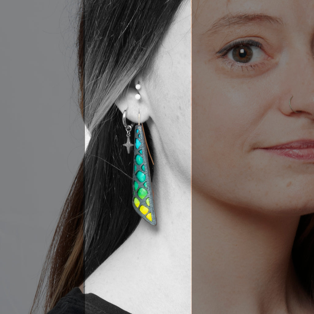 Chica luce los pendientes artesanales de arcilla polimérica Sunset con diseño de rejilla y degradado de color azul a amarillo.