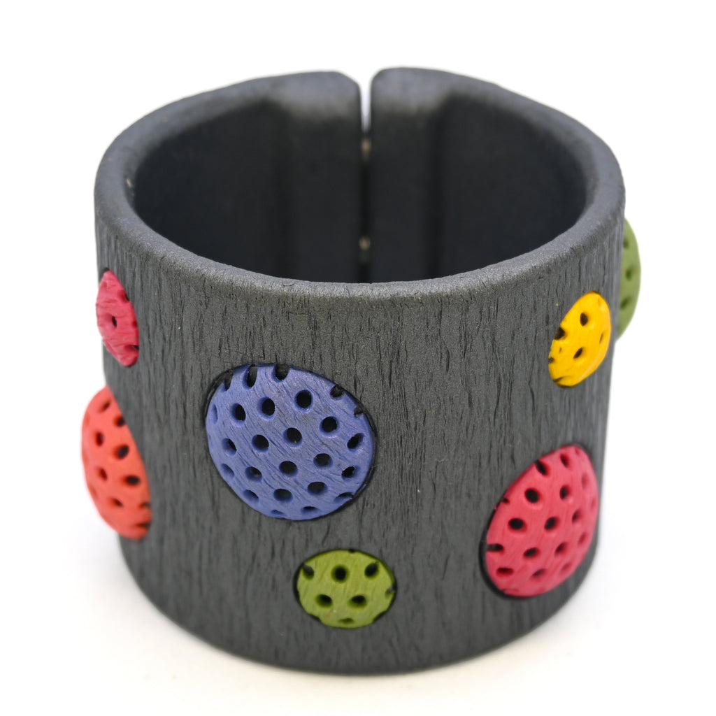Pulsera artesanal de arcilla polimérica con diseño en círculos de distintos tamaños en colores vibrantes.