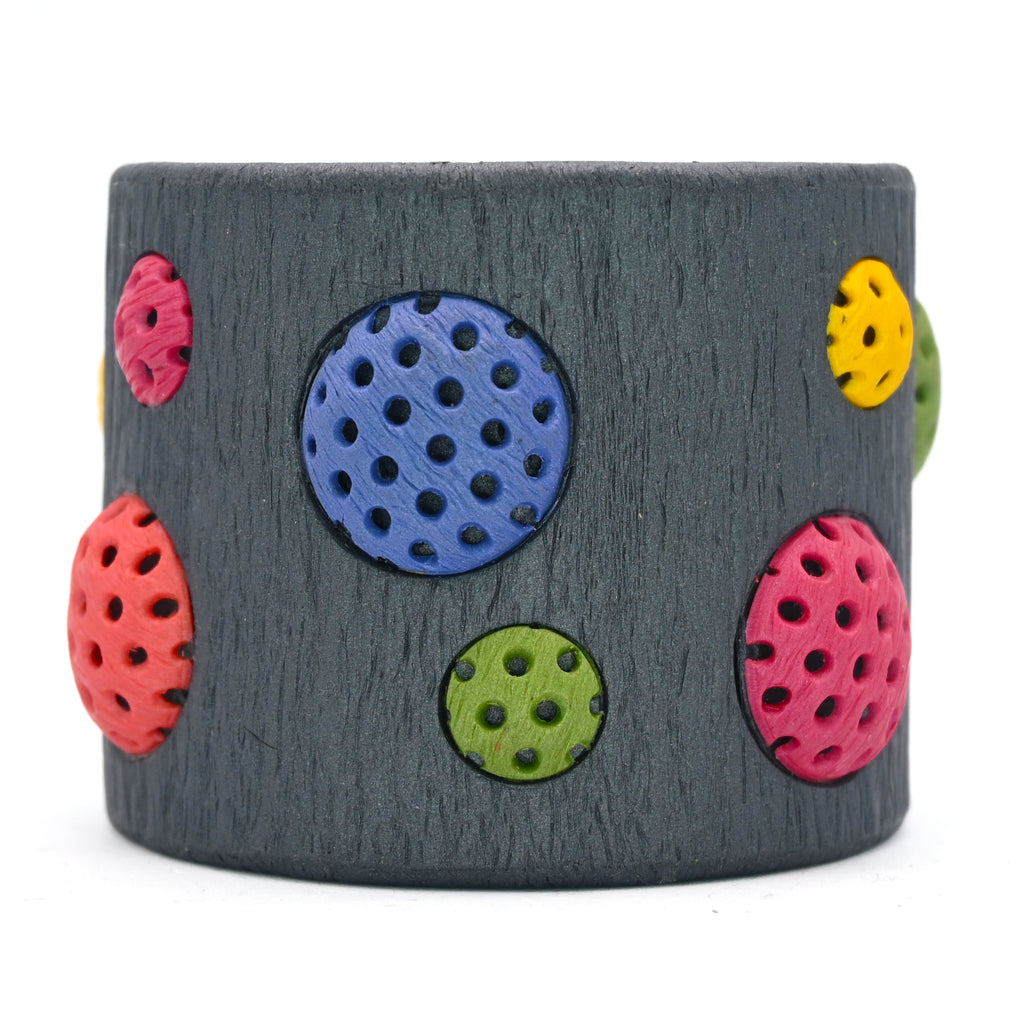 Pulsera artesanal de arcilla polimérica con diseño en círculos de distintos tamaños en colores vibrantes.